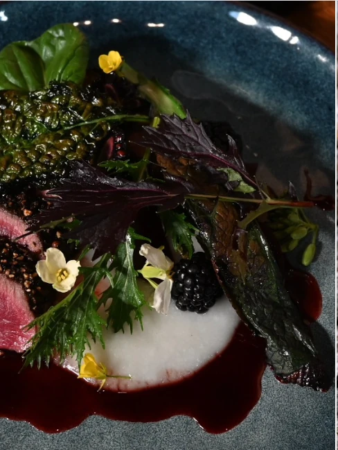 Seasonal plated dish with greens and edible flowers