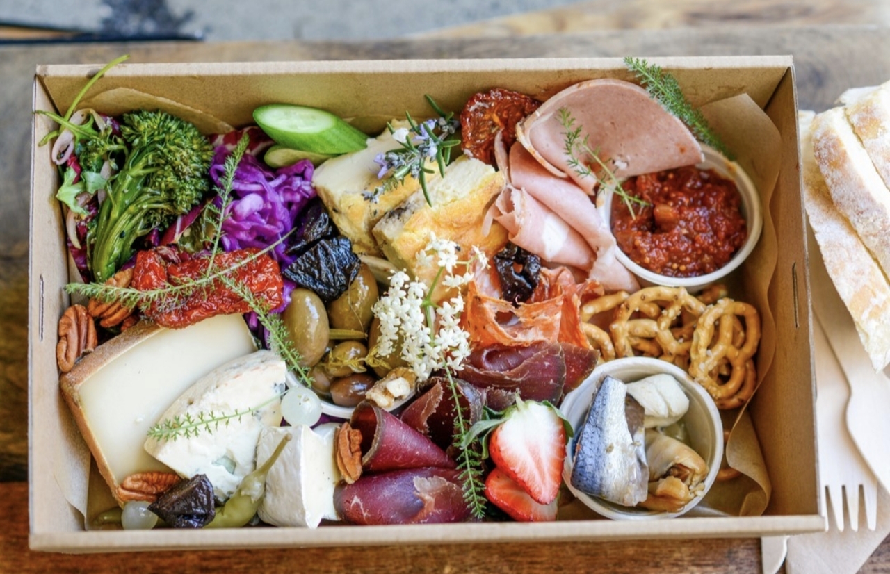 A generous grazing box with cheeses, cured meats, vegetables and preserves