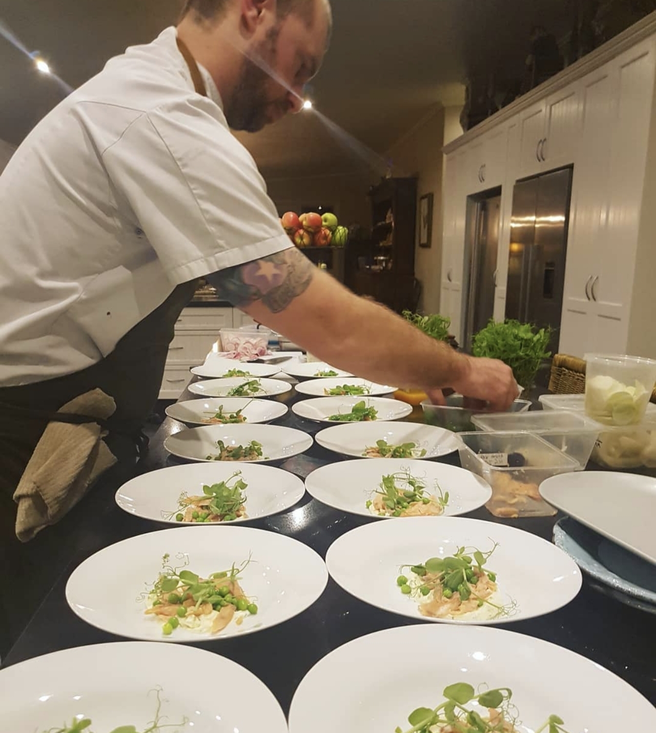 Chef Nick Gardner plating multiple courses in a private kitchen