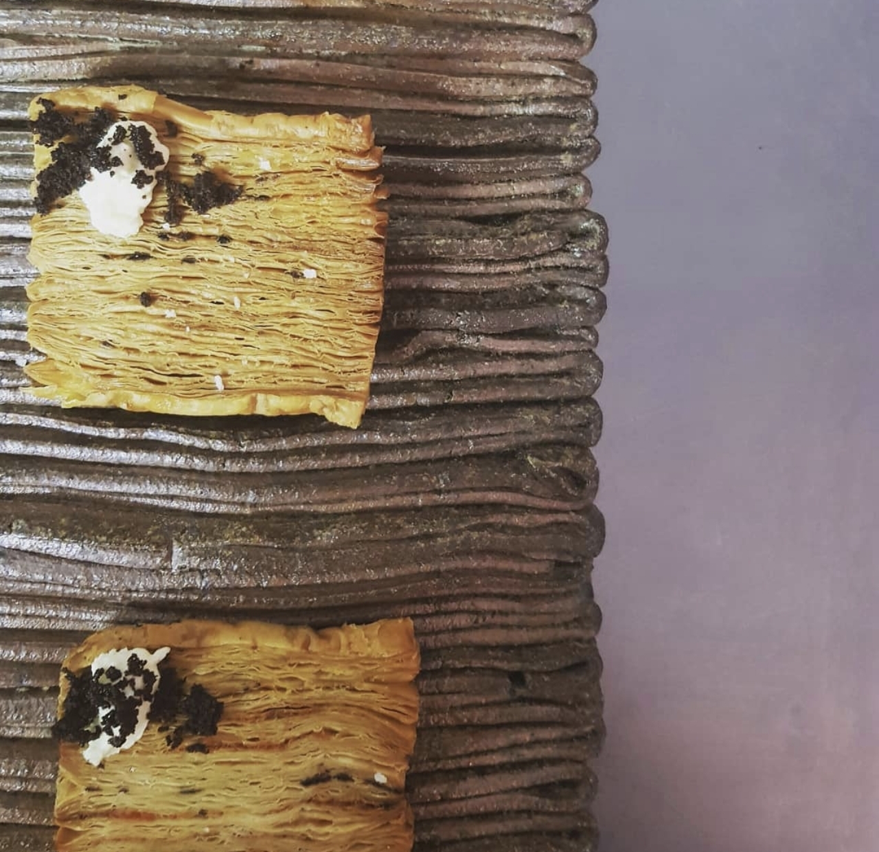 Crisp layered canapes topped with cream and black truffle