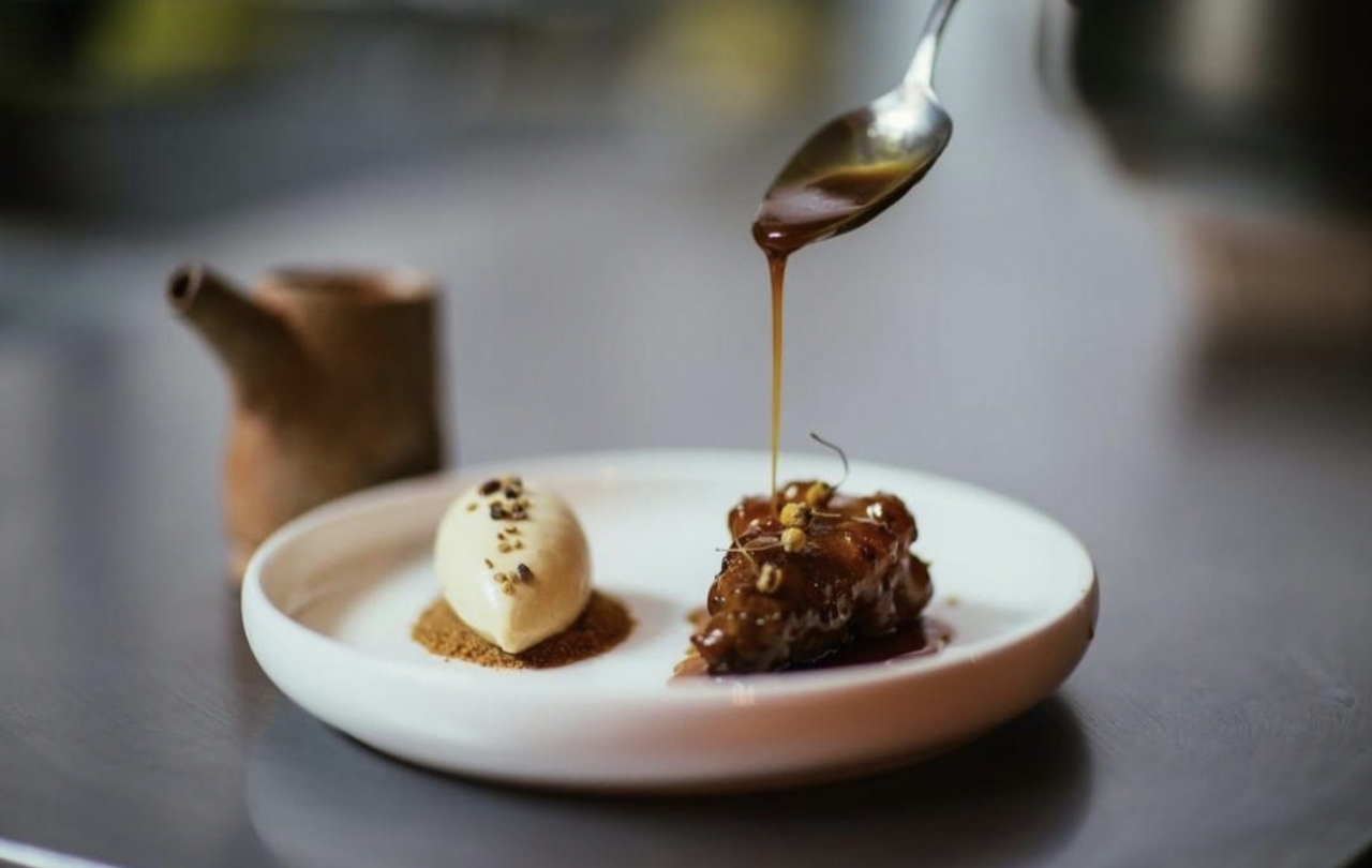 Dessert course finished with sauce poured from a spoon